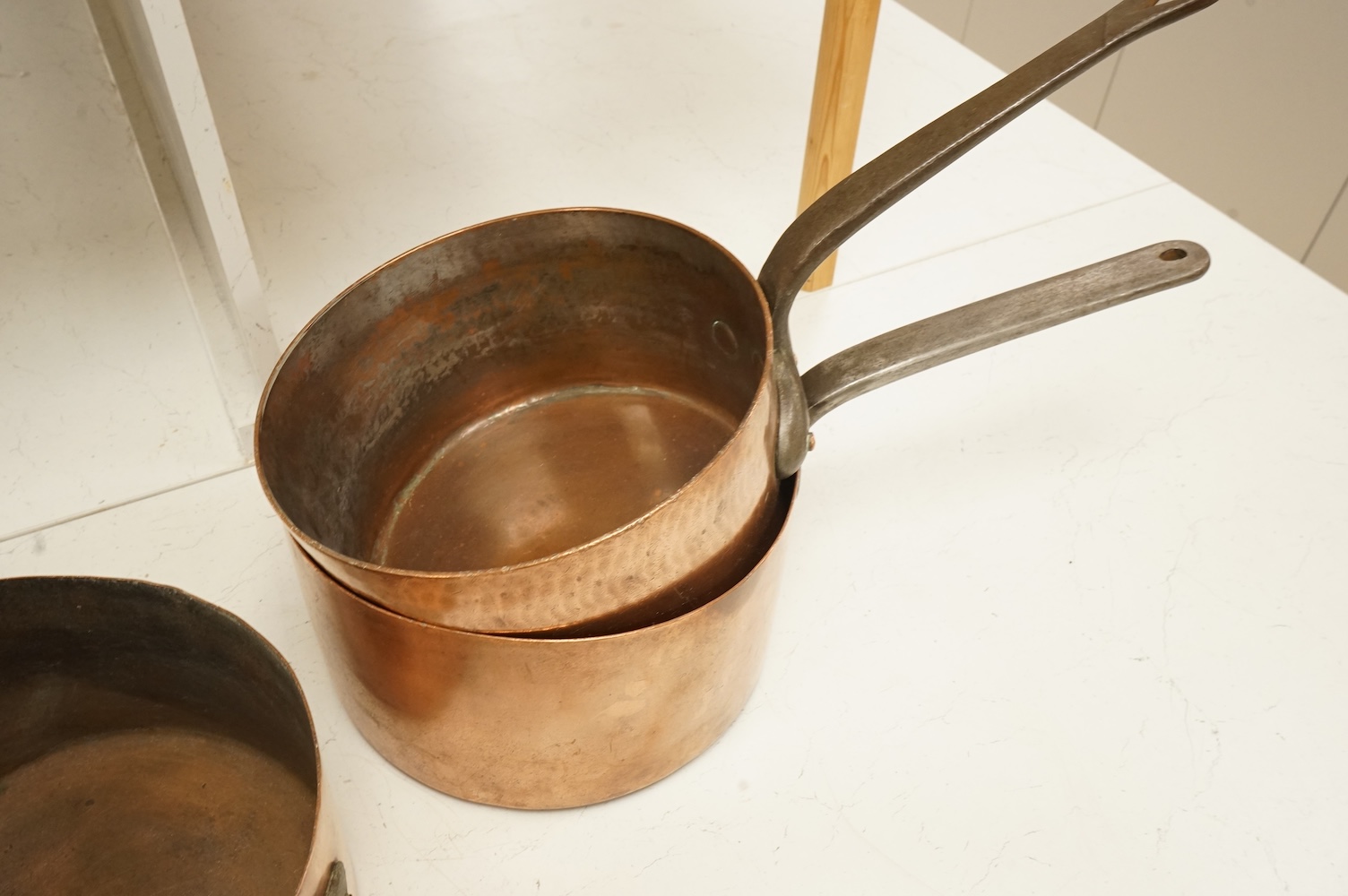 A graduated group of four large copper saucepans